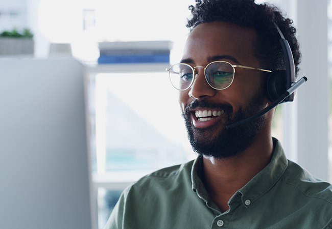 Man smiling at computer whilst working